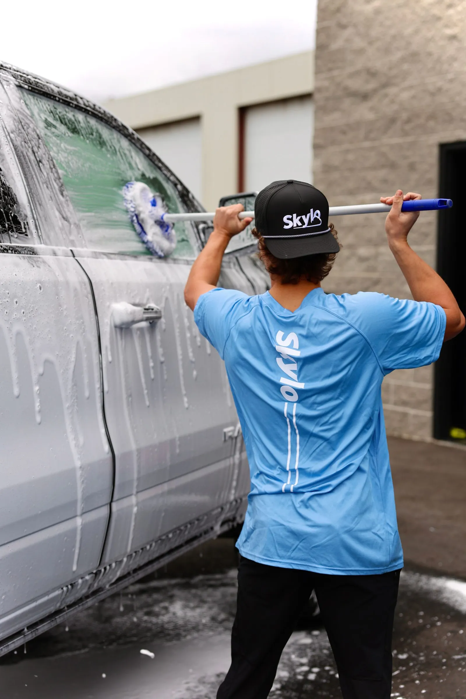 Skylo technician washing a vehicle exterior