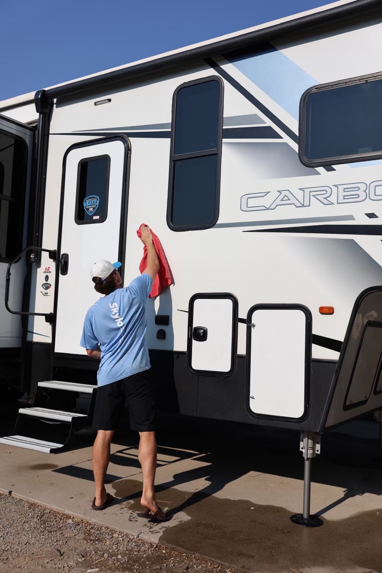 Skylo technician hand-drying the side of a travel trailer